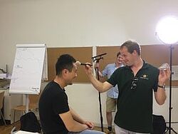 zwei Männer lachend gegenüber in einem Hochschulraum