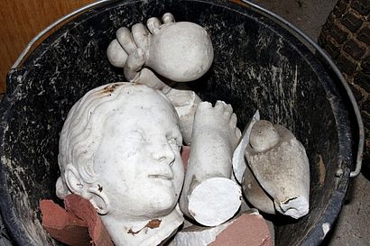 zerbrochene Statue in einem Eimer