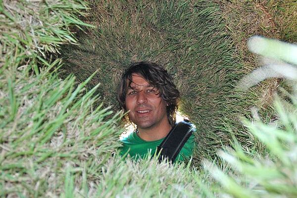 Mann umgeben von Kunstrasen