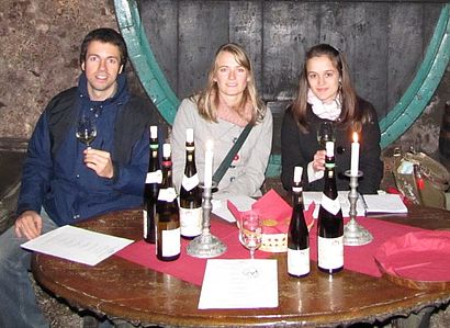 Studenten sitzen am Tisch mit Weinflaschen