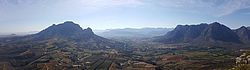 (v.l.n.r.) Blick auf den Simonsberg (1.399 m), die Ortschaften Kylemore und Lanquedoc und den Buller´s Kop (1.393 m). Zwischen den Bergen sind Weinberge angelegt, die vom kühlen Wind profitieren, der von den Berghängen herab weht.