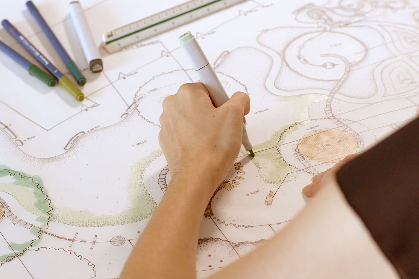 Eine Hand coloriert einen Plan mit Bäumen, Plätzen und Spielmöglichkeiten. © Hochschule Geisenheim