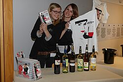 Zwei Studentinnen halten ein Shirt und eine DVD in ihren Händen