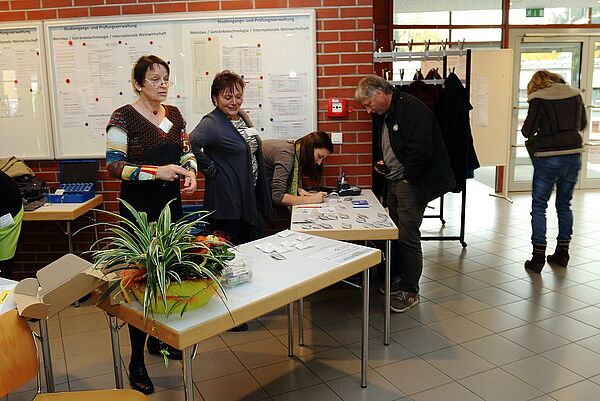 Frauen stehen hinter Tischen