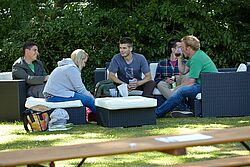 Gruppe sitzt in Loungemoebeln