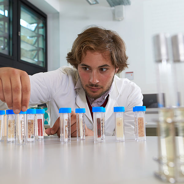 Ein junger Mann im Laborkittel hantiert mit Abklatsch-Proben. © Hochschule Geisenheim / ppsstudios.com