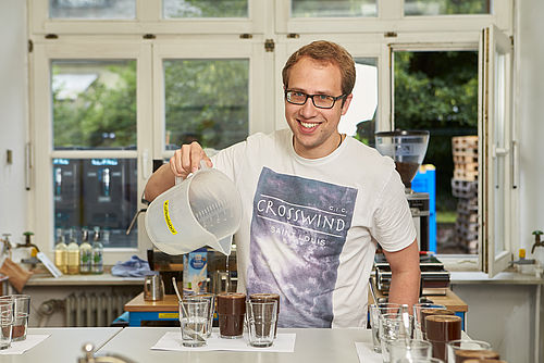 Ein Student gießt heißes Wasser in Gläser mit Kaffeepulver © Hochschule Geisenheim / ppsstudios.com