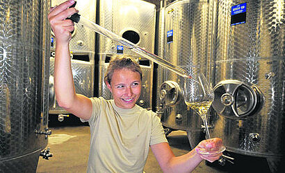 studentin mit Weinglas und Pinzette in den Haenden 