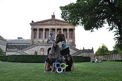 Studenten bilden Pyramide mit Hochschulzeichen