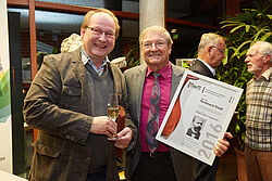 Männer stossen lachend an mit Blick in die Kamera