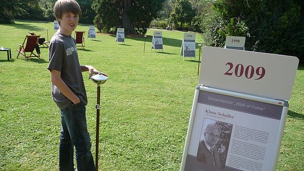 Simon Loenarz vor Schild von 2009