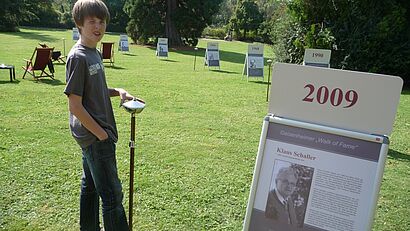 Simon Loenarz vor Schild von 2009