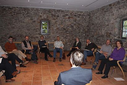 Dozenten sitzen im Stuhlkreis