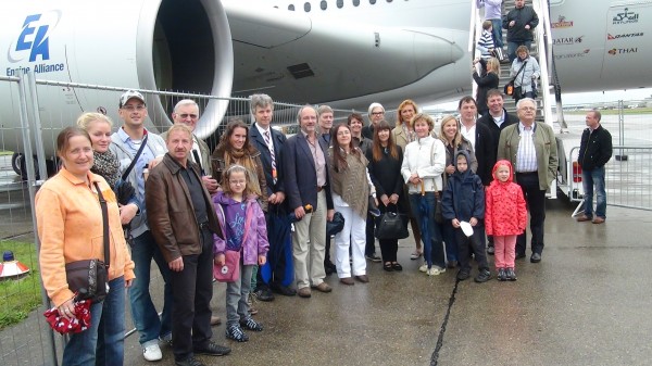 Gruppe steht vor einem Flugzeug