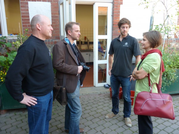 Drei Männer und eine Frau stehen draussen