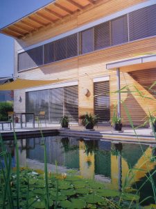 privater Schwimmteich vor modernem Haus